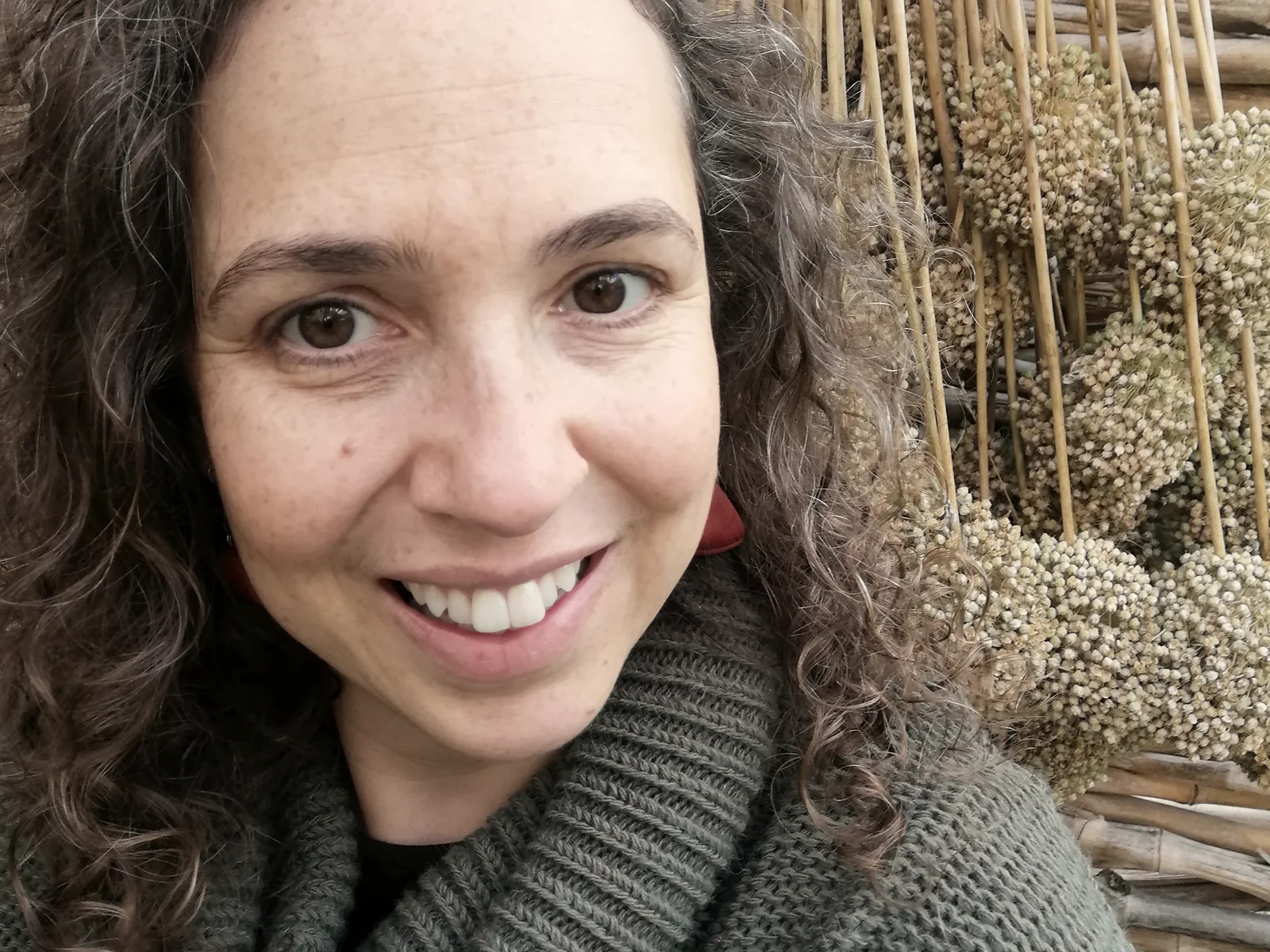 Eugénia Amaro, psicóloga, em retrato de luz natural, junto a uma parede de canas.